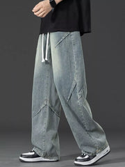 Men's blue vintage-inspired oversized jeans with drawstring waist and unique panel detailing.