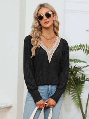 Black ribbed knit sweater with crochet V-neck detail and long sleeves.