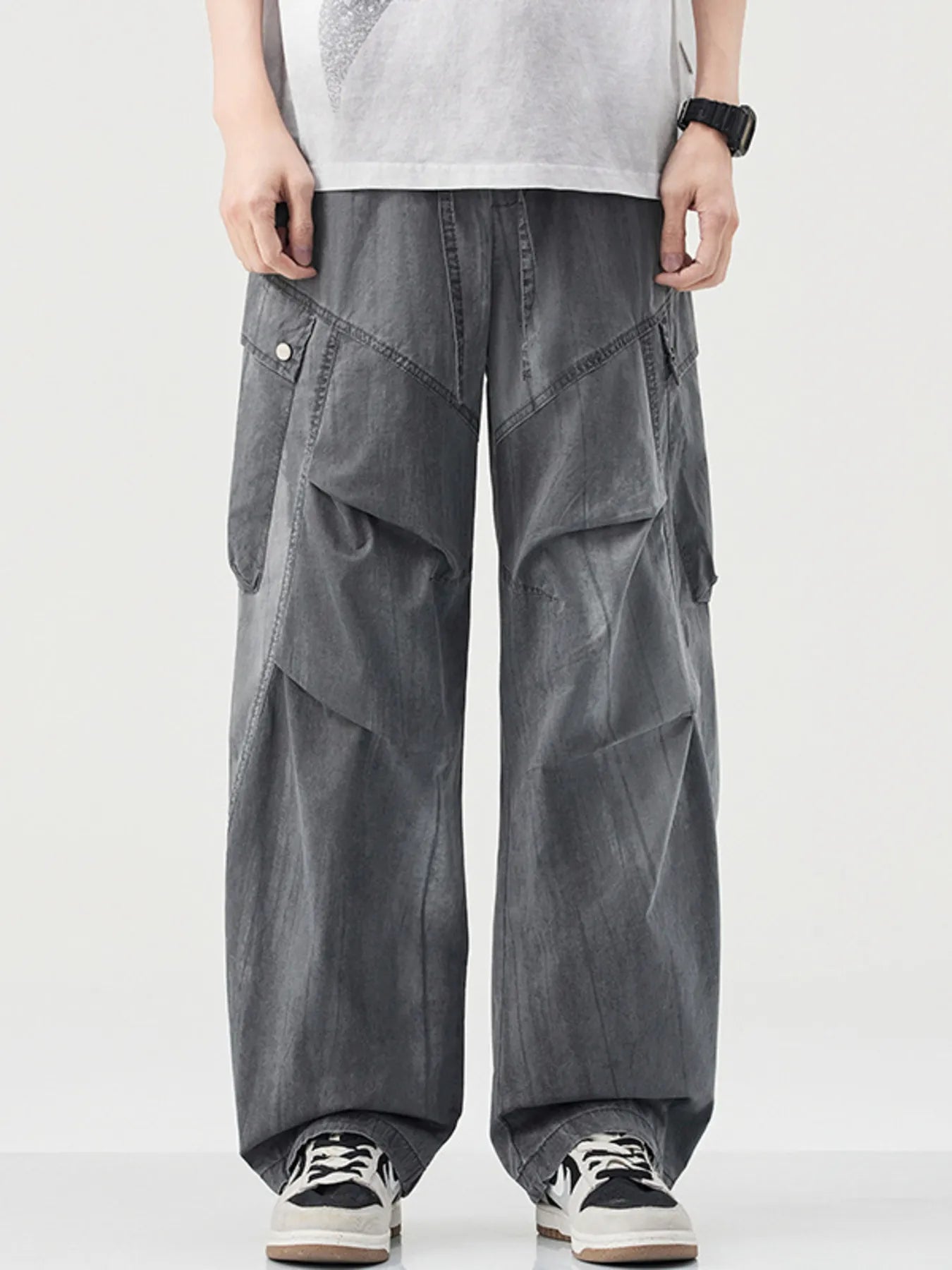 Loose fit grey cargo pants with drawstring and multiple pockets.