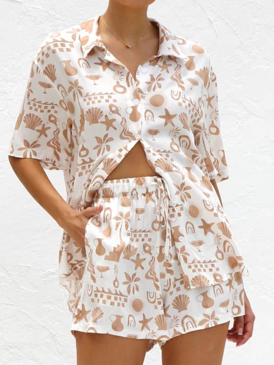 White resort set with tan beach graphic print, button-up shirt and drawstring shorts.
