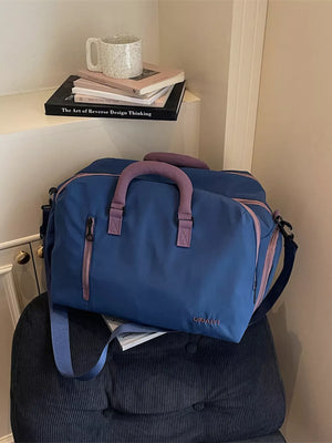 Blue travel organizer bag with pink accents and adjustable strap
