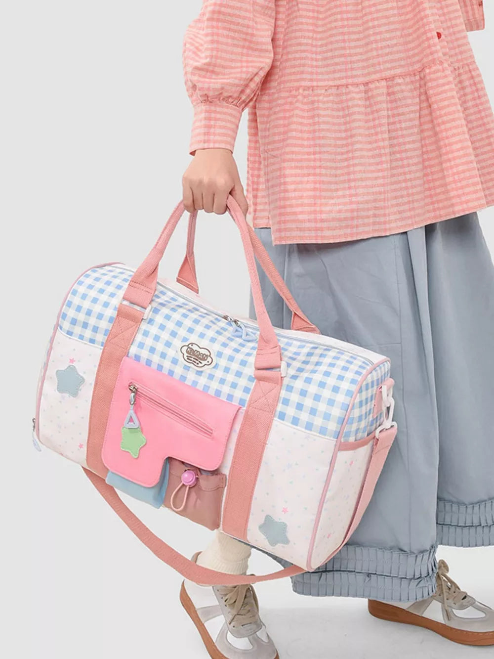 Charming color block travel bag with blue gingham, stars, and pink pockets.