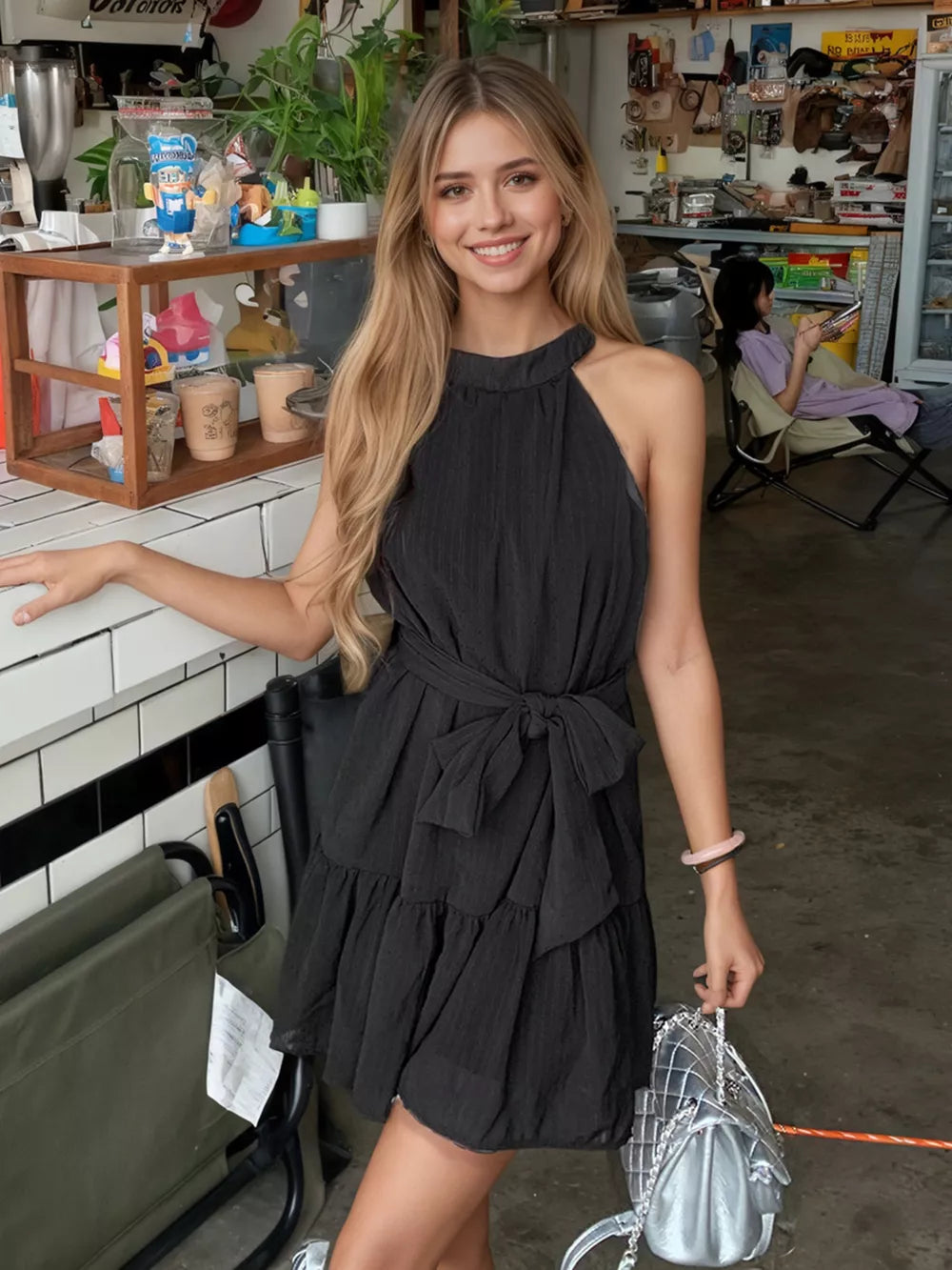 Black halter neck mini dress with tied waist and tiered skirt