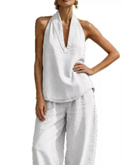 Chic white halter neck top with deep V-neck and wide-leg pants.
