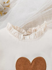 Cream baby top with ruffled neckline and brown corduroy heart applique.