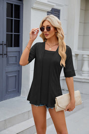 Black textured layered blouse with square neckline and short sleeves.