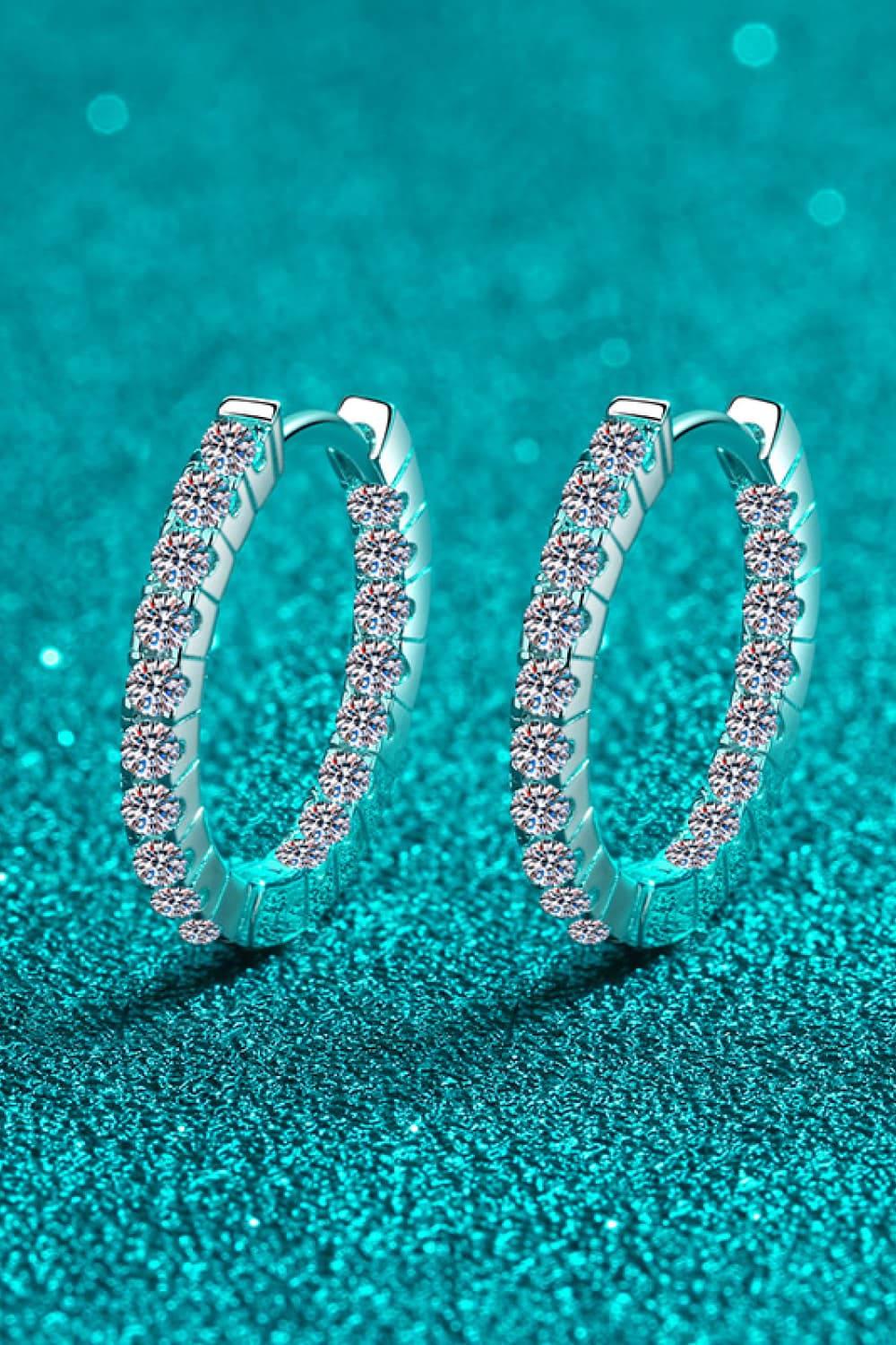 Silver pavé crystal huggie hoop earrings with sparkling stones.