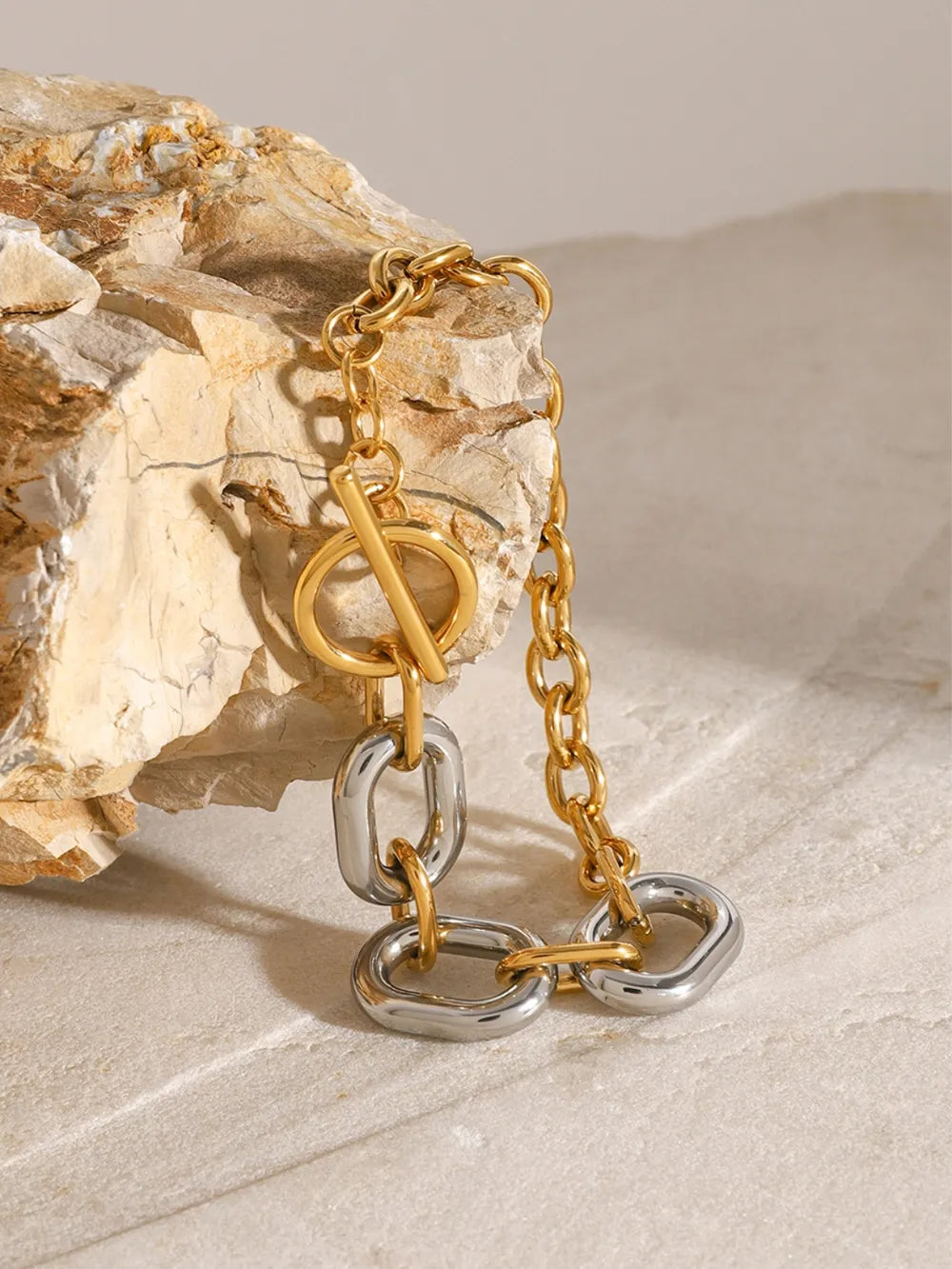 Two-tone chain link bracelet with toggle closure, gold and silver oval links.