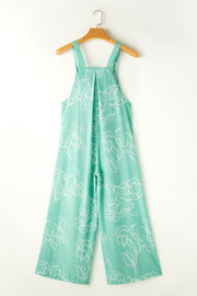 Turquoise botanical print wide-leg jumpsuit with wide straps and pleats.