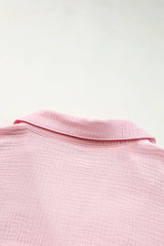 Pink cotton casual shirt with textured fabric and button-down collar detail.
