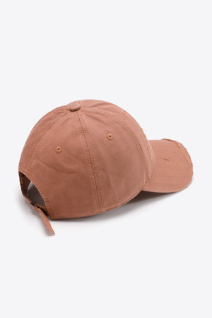 Rugged baseball cap in coral with distressed brim and adjustable strap.