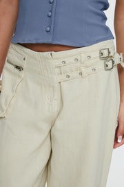 Cream cotton denim flared trousers with double buckle waist detail and zipper pocket.