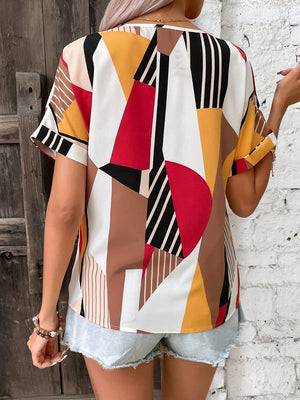 Geometric print V-neck blouse with short sleeves and a multicolor abstract pattern.