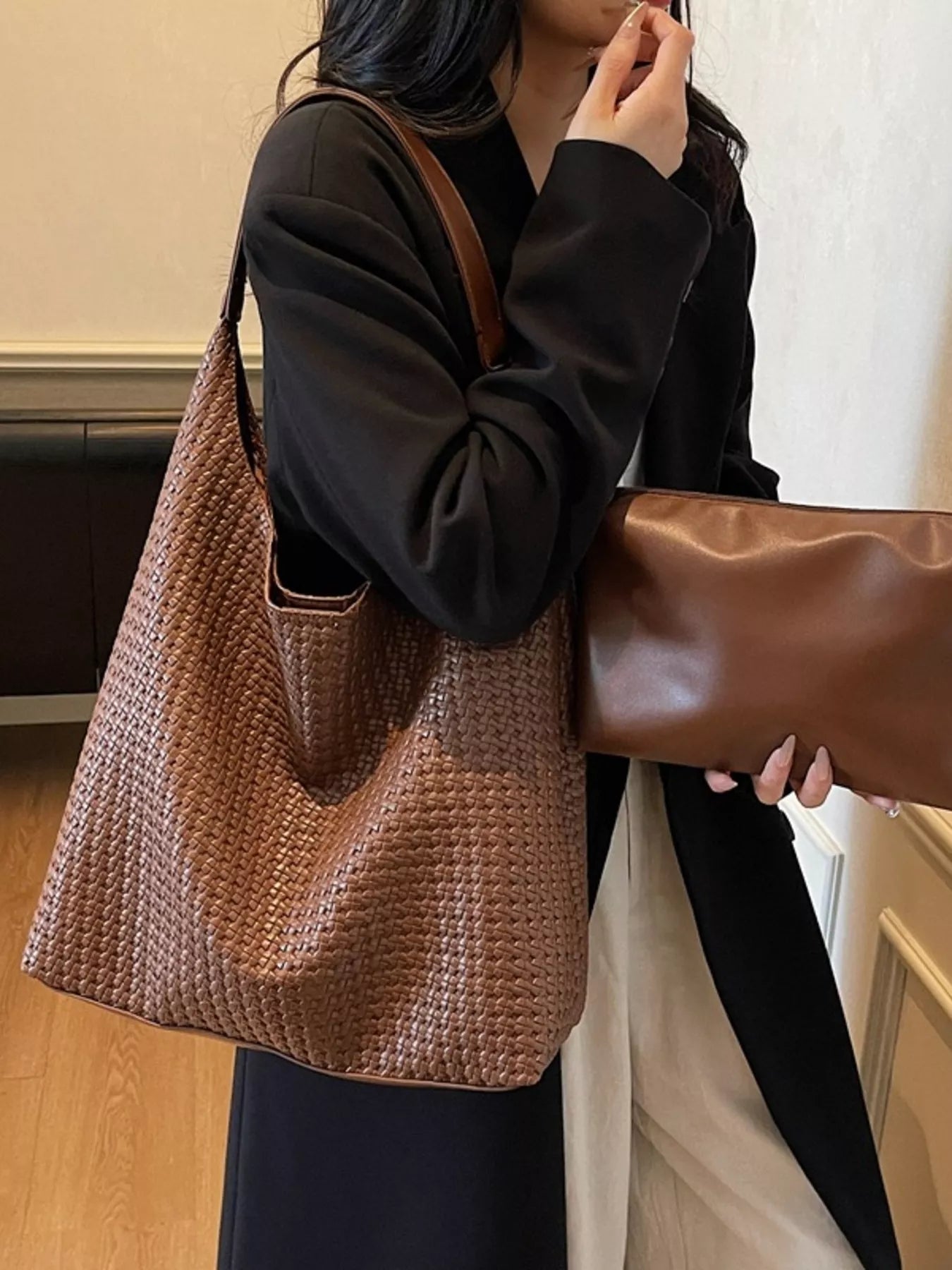 Brown woven straw tote bag with leather straps and a matching clutch.