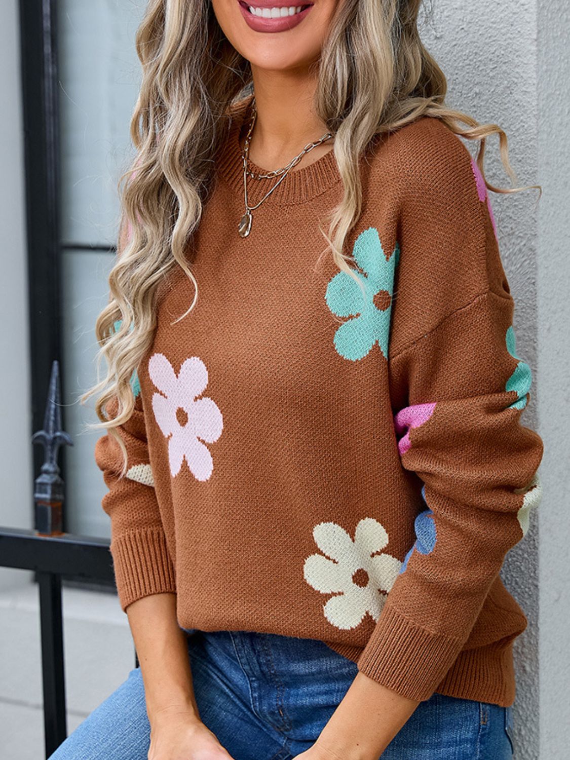 Brown crewneck sweater with colorful floral print, acrylic knit, long sleeves, ribbed cuffs and hem.