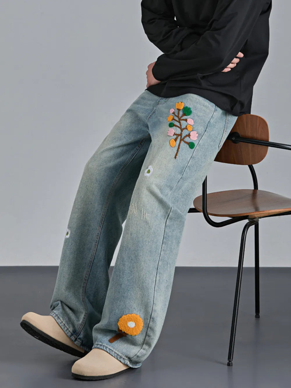 Appliquéd relaxed fit blue cotton jeans with floral embroidery detail.