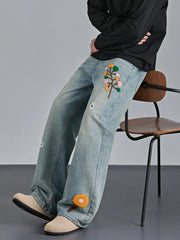 Appliquéd relaxed fit blue cotton jeans with floral embroidery detail.