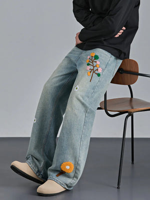 Appliquéd relaxed fit blue cotton jeans with floral embroidery detail.