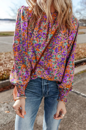 Purple floral print blouse with gathered sleeves and mock neck.