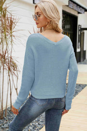 Blue waffle knit sweater with V-neck and long sleeves, styled with jeans.