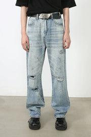 Baggy ripped denim jeans in medium wash with distressed details and a relaxed fit.