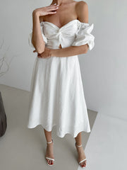 White off-shoulder midi dress with twisted bust detail, cutout, and puff sleeves.