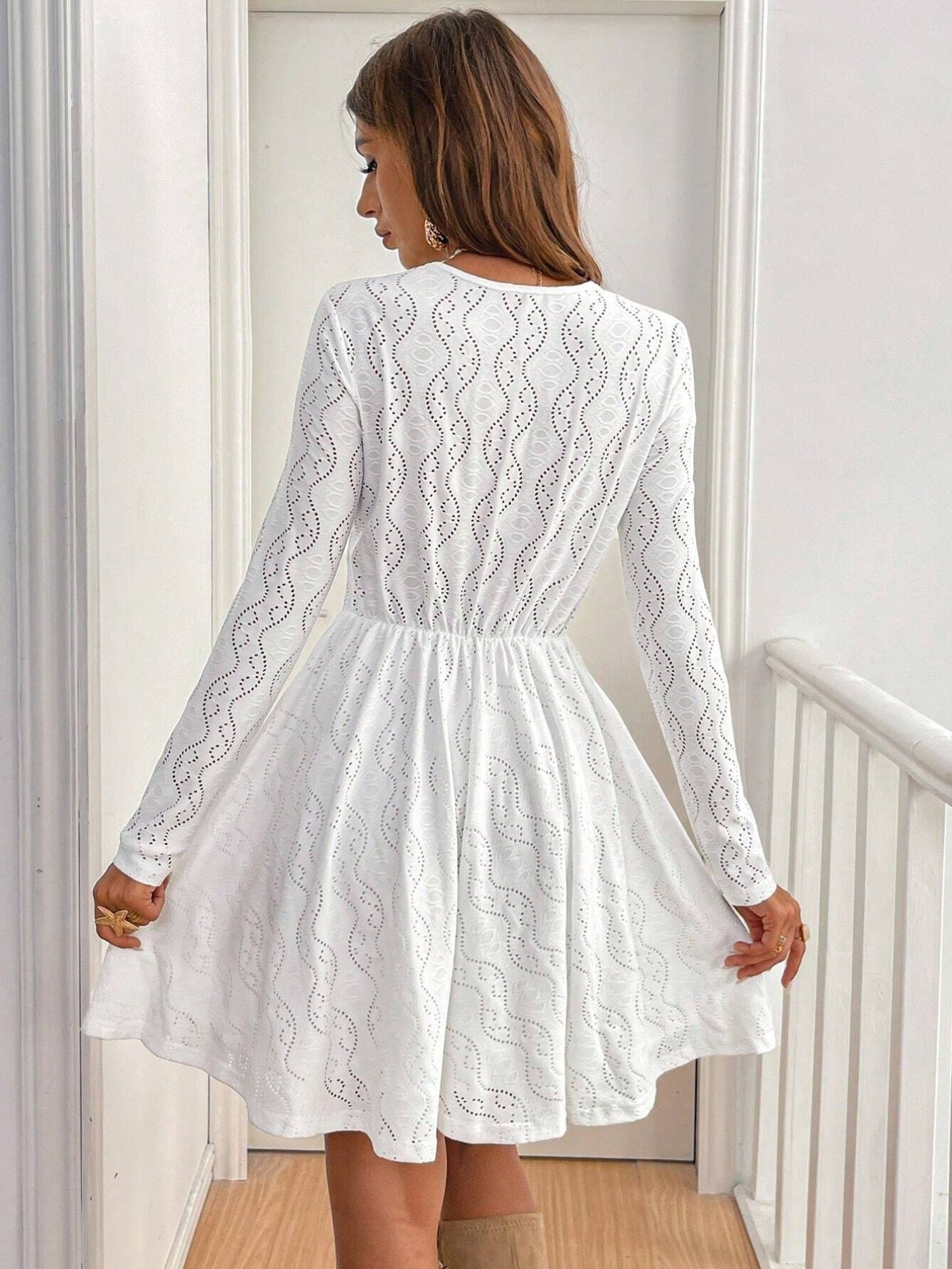 White lace openwork V-neck dress with long sleeves and an A-line skirt.