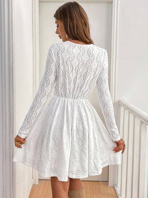White lace openwork V-neck dress with long sleeves and an A-line skirt.