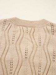 Beige knit sweater with V-neck and cable knit detail.