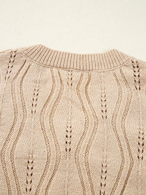 Beige knit sweater with V-neck and cable knit detail.