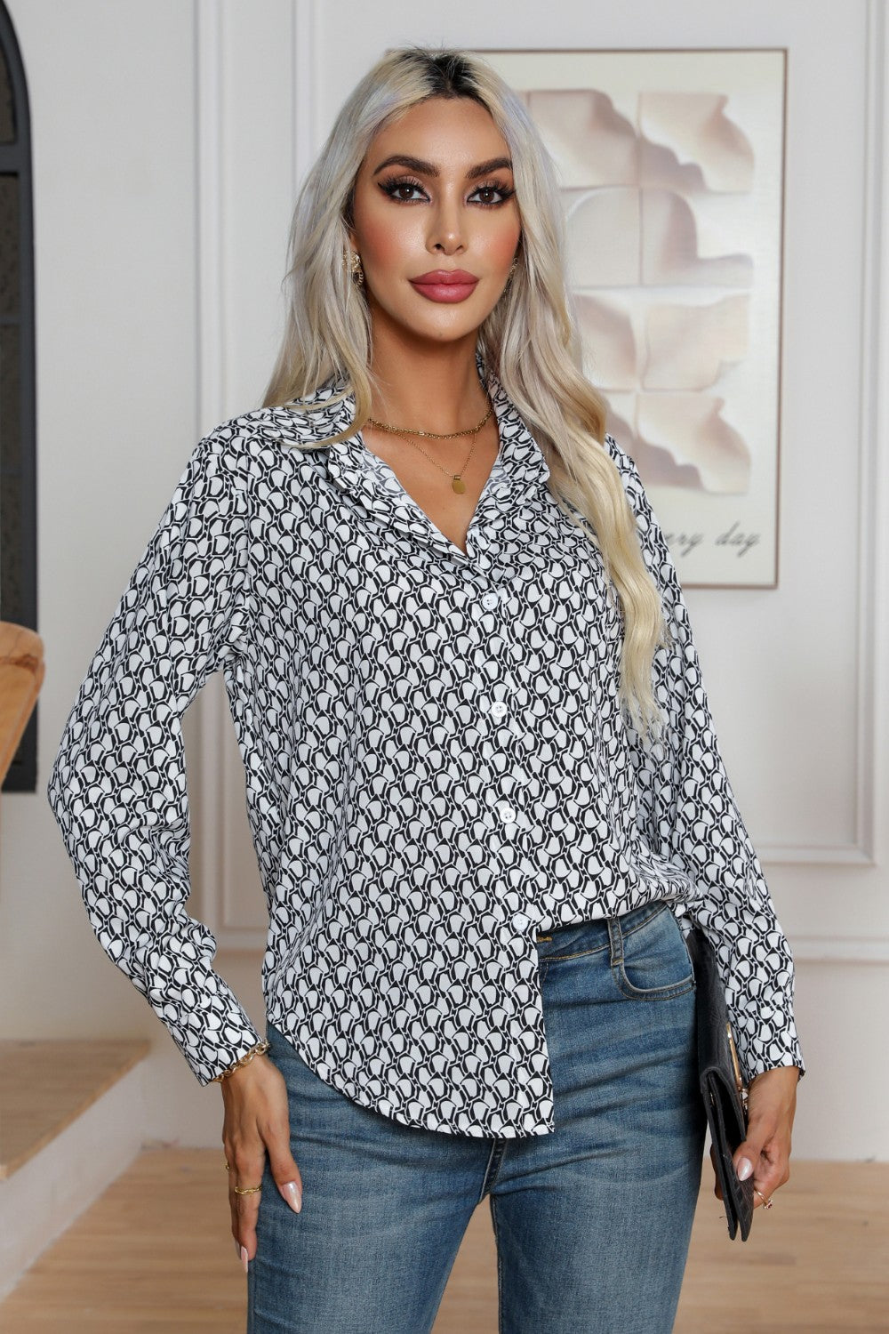 White collared blouse with black monogram print, button front, and long sleeves.