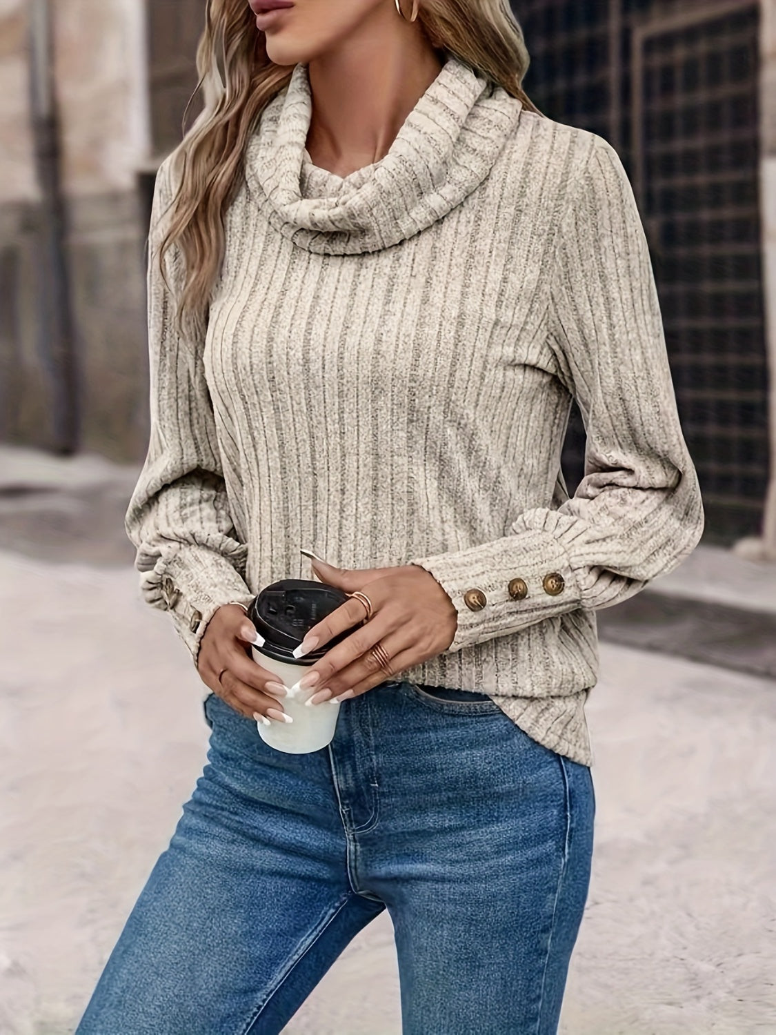 Tan ribbed cowl neck sweater with button cuff detail and long sleeves.