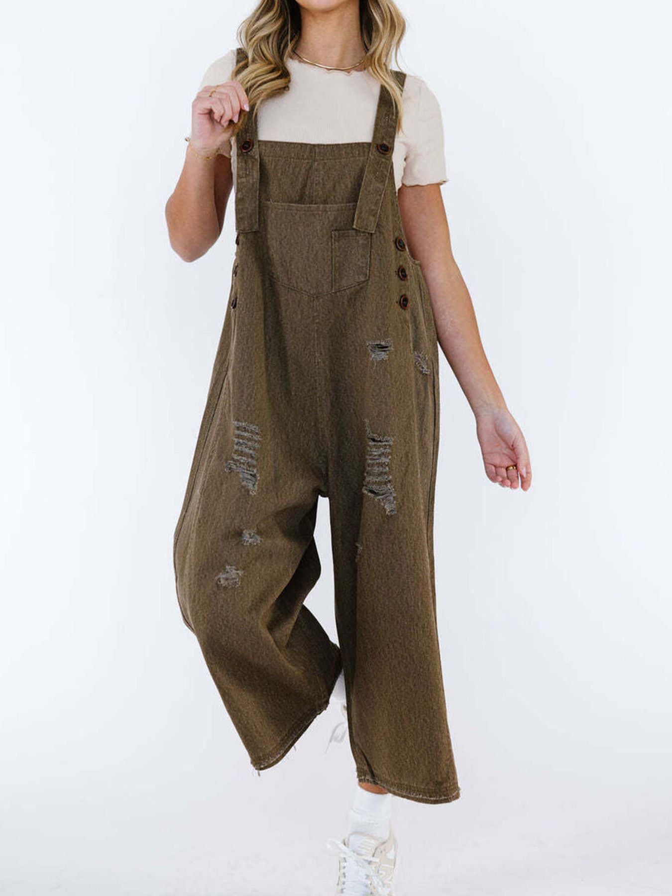 Ripped relaxed fit brown denim overalls with adjustable straps and button details.