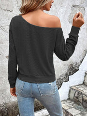 Black off-shoulder eyelet knit top with long sleeves and a relaxed fit.