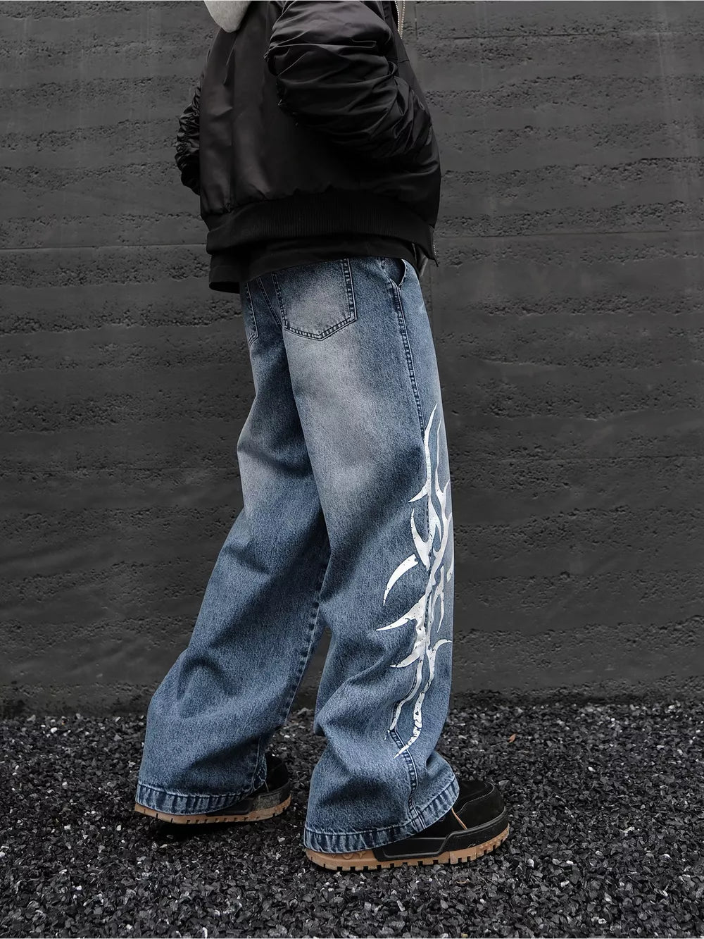 Men's blue denim wide leg jeans with tribal print and distressed details.
