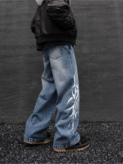 Men's blue denim wide leg jeans with tribal print and distressed details.