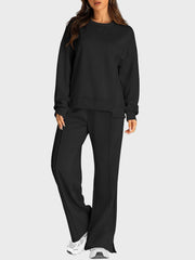 Black seamed loungewear set with crewneck sweatshirt and slit-front wide-leg trousers.