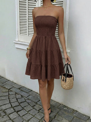 Gathered bodice tiered ruffle mini dress in dark brown, strapless with smocked bust and flowy skirt.