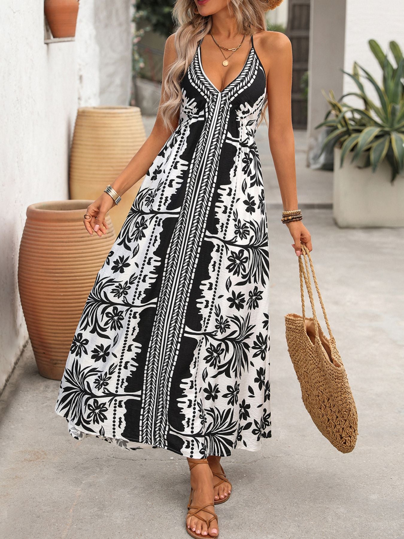 Maxi dress with black and white floral print, halter neck, and deep V.