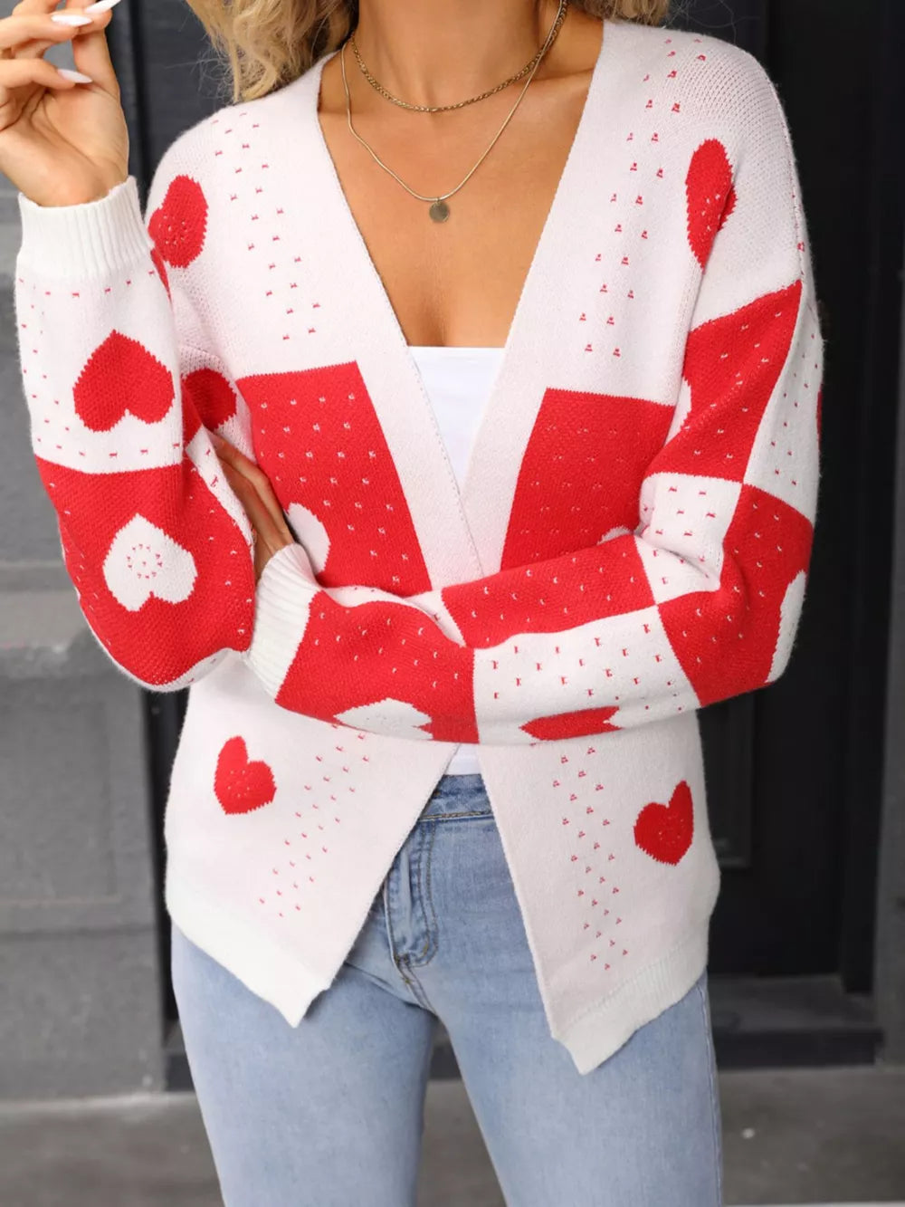 White and red heart print acrylic cardigan with a V-neck and long sleeves.