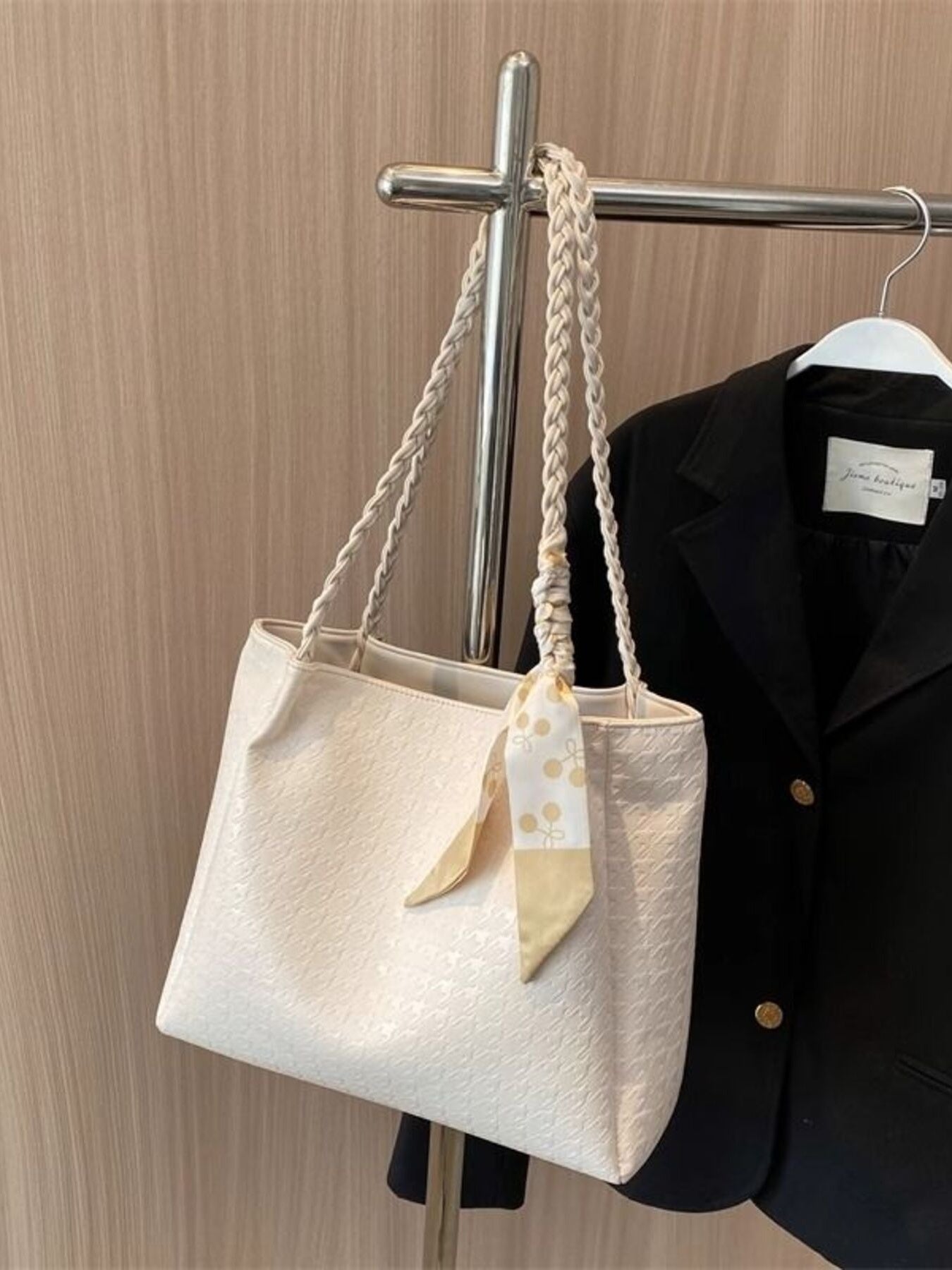Elegant ivory tote bag with braided handles and a decorative scarf.