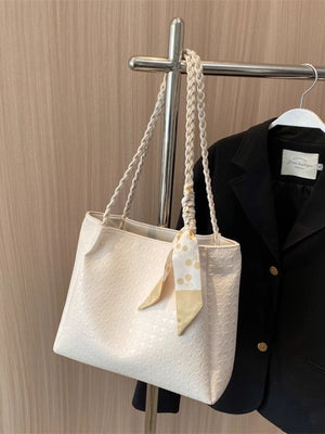 Elegant ivory tote bag with braided handles and a decorative scarf.