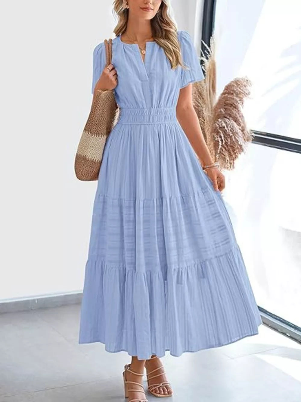 Light blue ruched V-neck tiered midi dress with short sleeves and smocked waist.