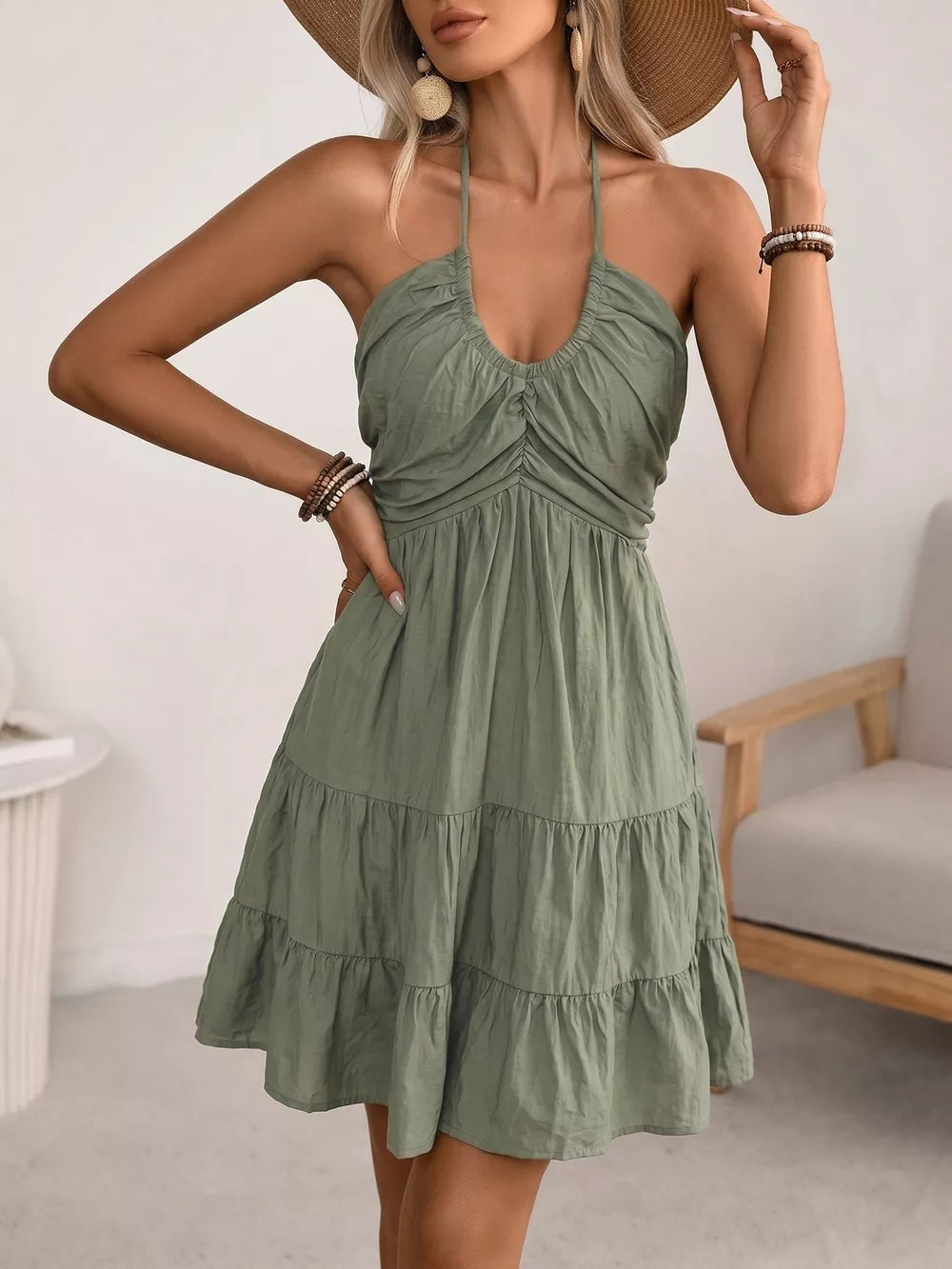 Green smocked halter mini dress with tiered skirt and ruched bodice.