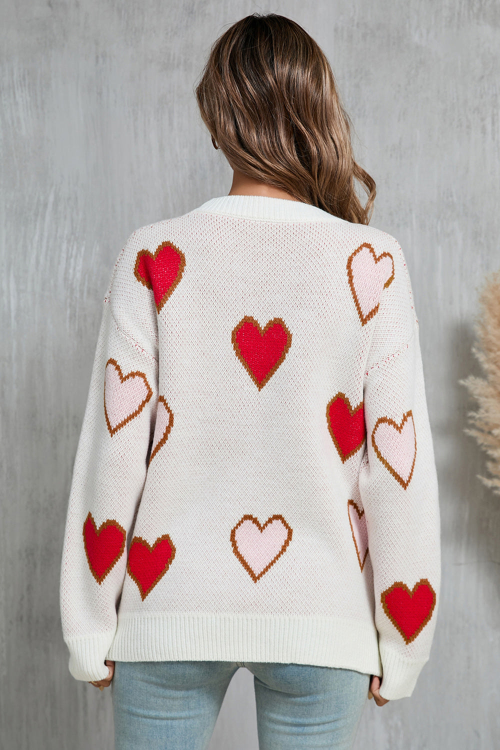 White knit crewneck sweater with red and pink heart motif, acrylic.