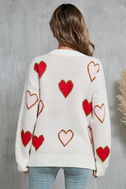 White knit crewneck sweater with red and pink heart motif, acrylic.