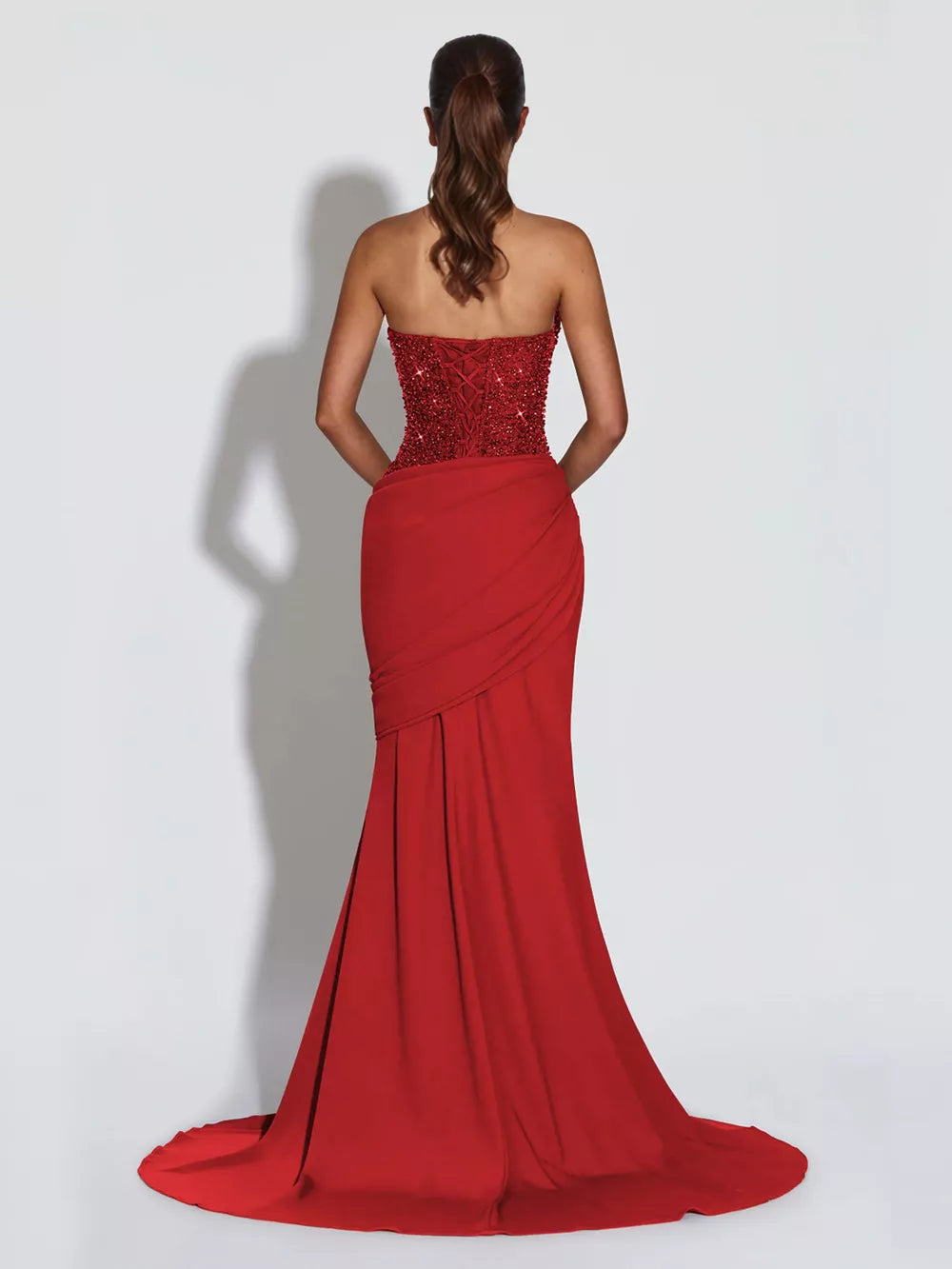 Scarlet sequin corset maxi gown with draped skirt and lace-up back.