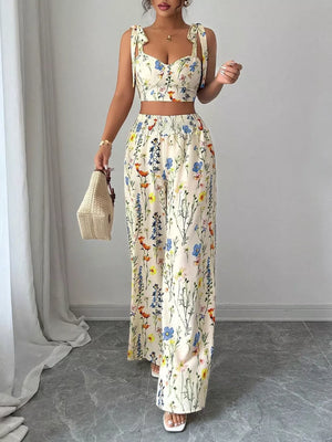 Floral print two-piece set with cream crop top and wide-leg pants, featuring adjustable tie straps.