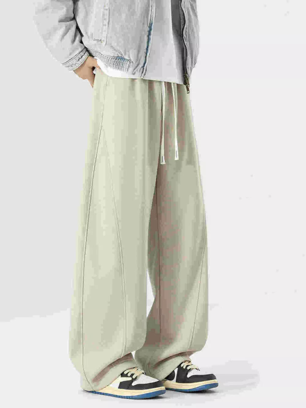 Beige wide-leg drawstring sweatpants with contrast stitching and a relaxed fit.