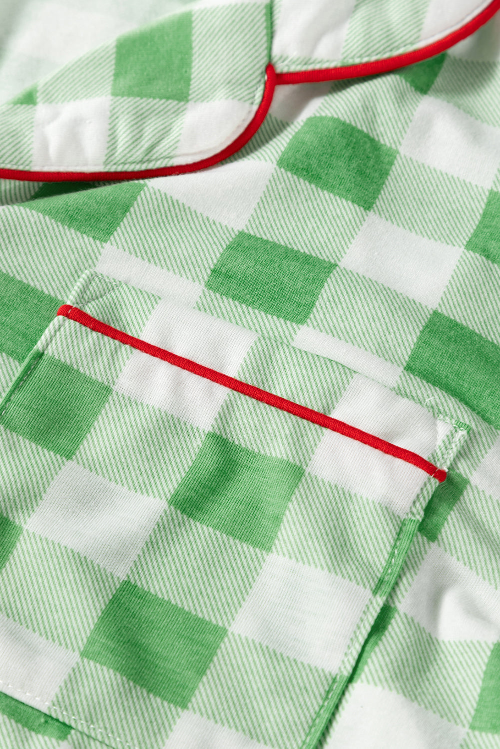 Light green gingham pajama set with red trim detail on collar and pocket.